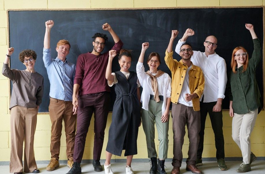 Professeurs d'école contents devant un tableau